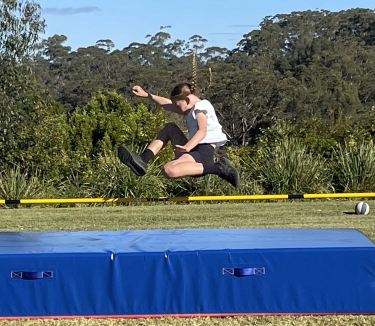 A student clearing the bar at high jump during the athletics carnival