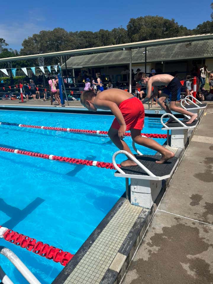 Two year six students about to dive into their lanes at the school swimming carnival