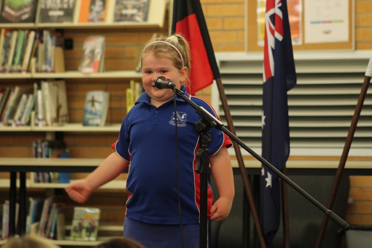 A kindergarten student speaking at a microphone at the public speaking competition